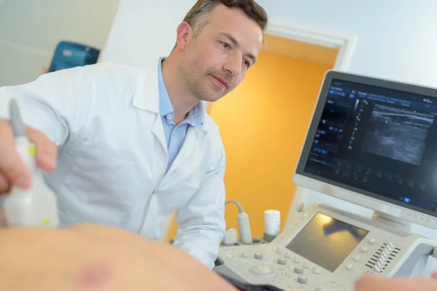 Lege som holder et ultralydapparat på en mage