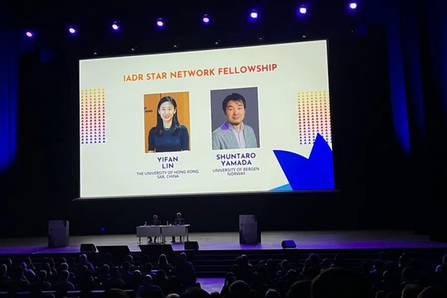 A large screen with a large screen and a group of people on a stage