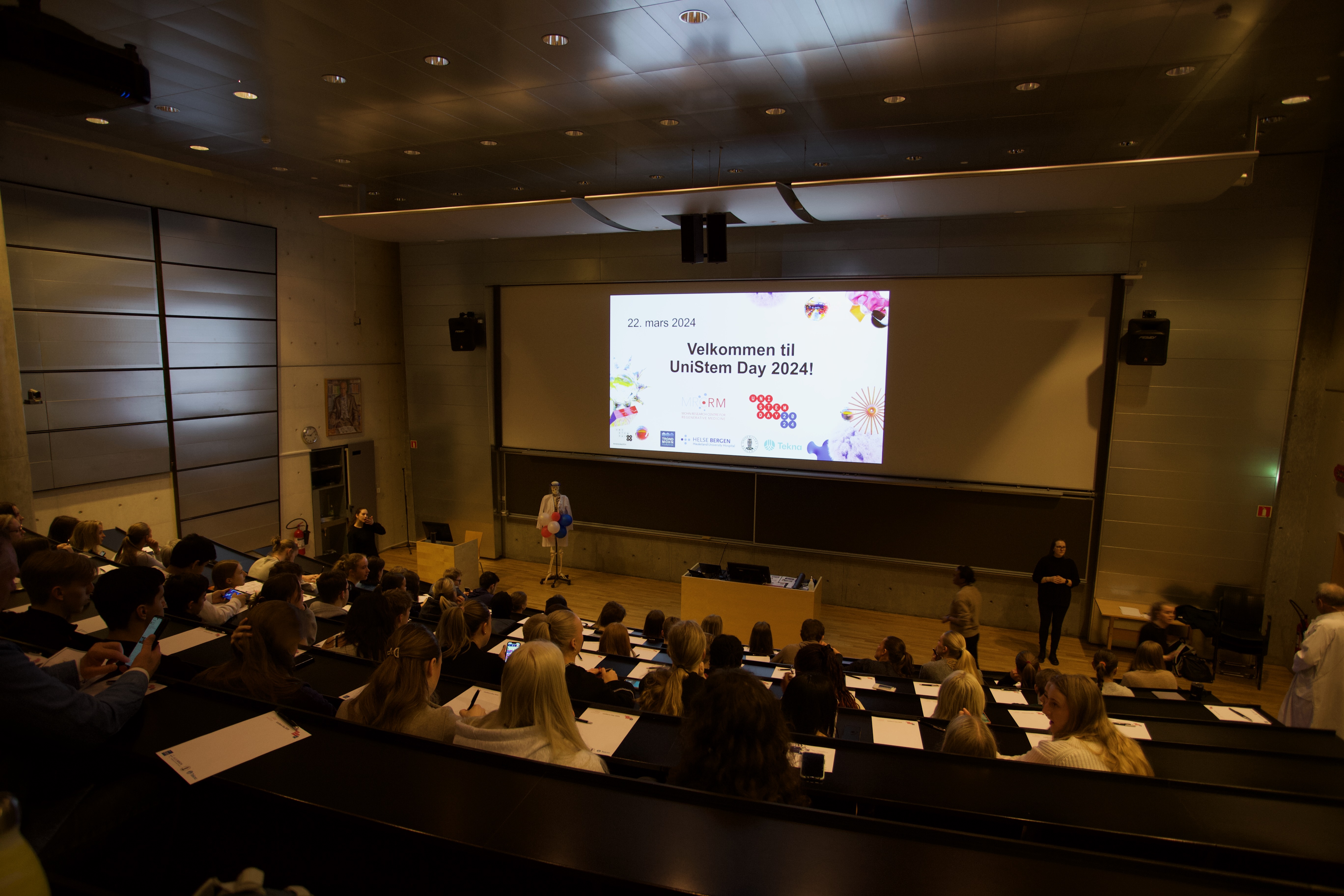 A group of people in a room with a projector screen
