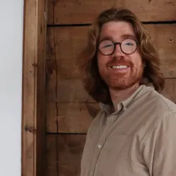 En mann med langt hår og briller