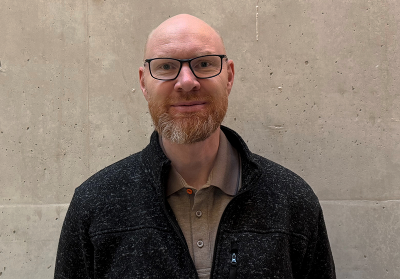 En mann med skjegg og briller