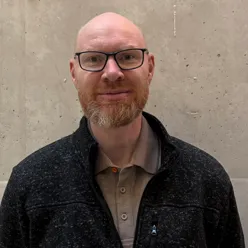 En mann med skjegg og briller