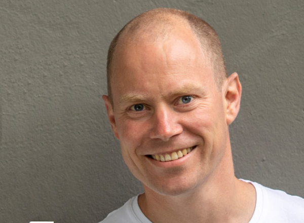 En mann som smiler til kameraet