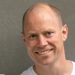 En mann som smiler til kameraet