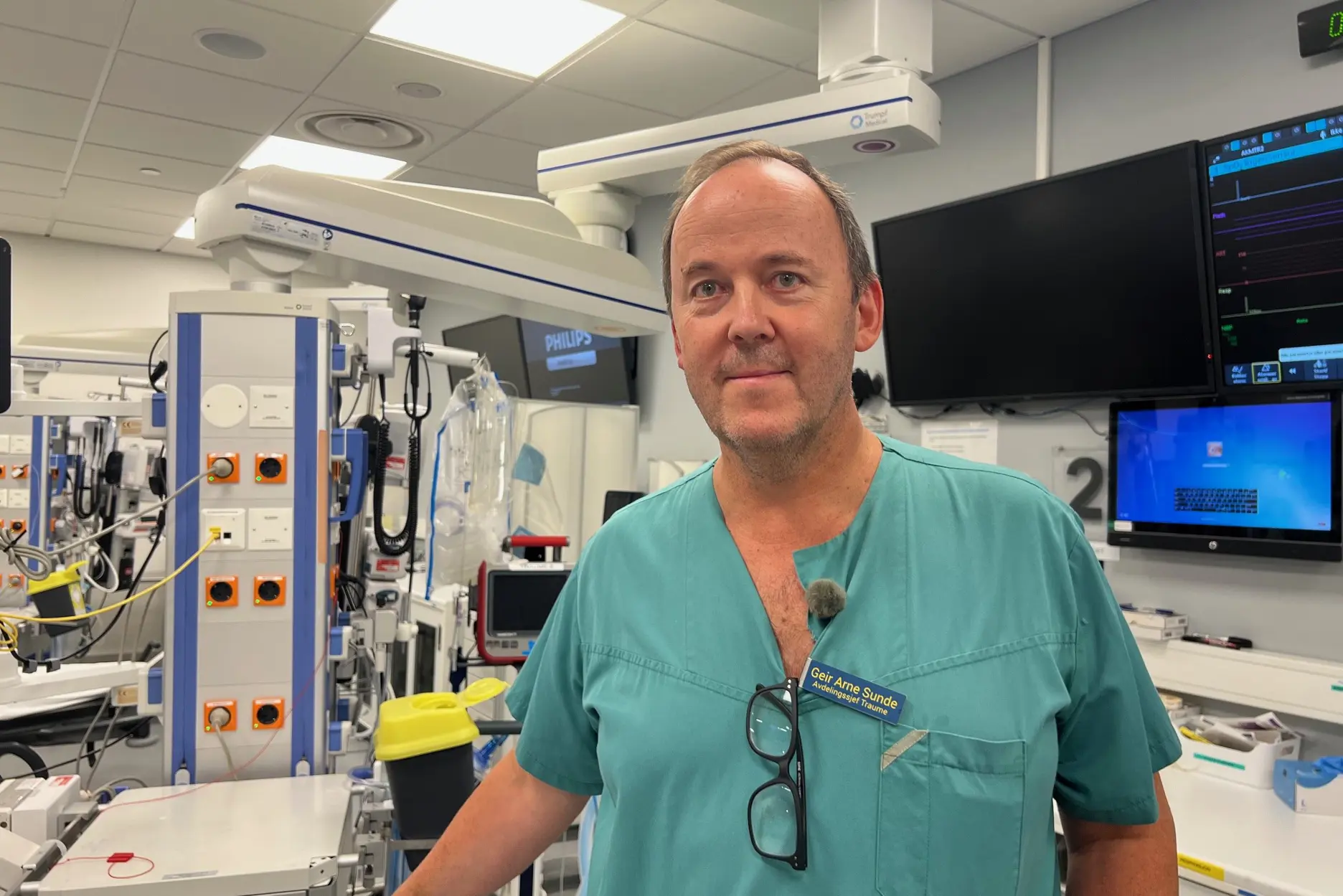 En mann som står i et rom med datamaskiner og skjermer