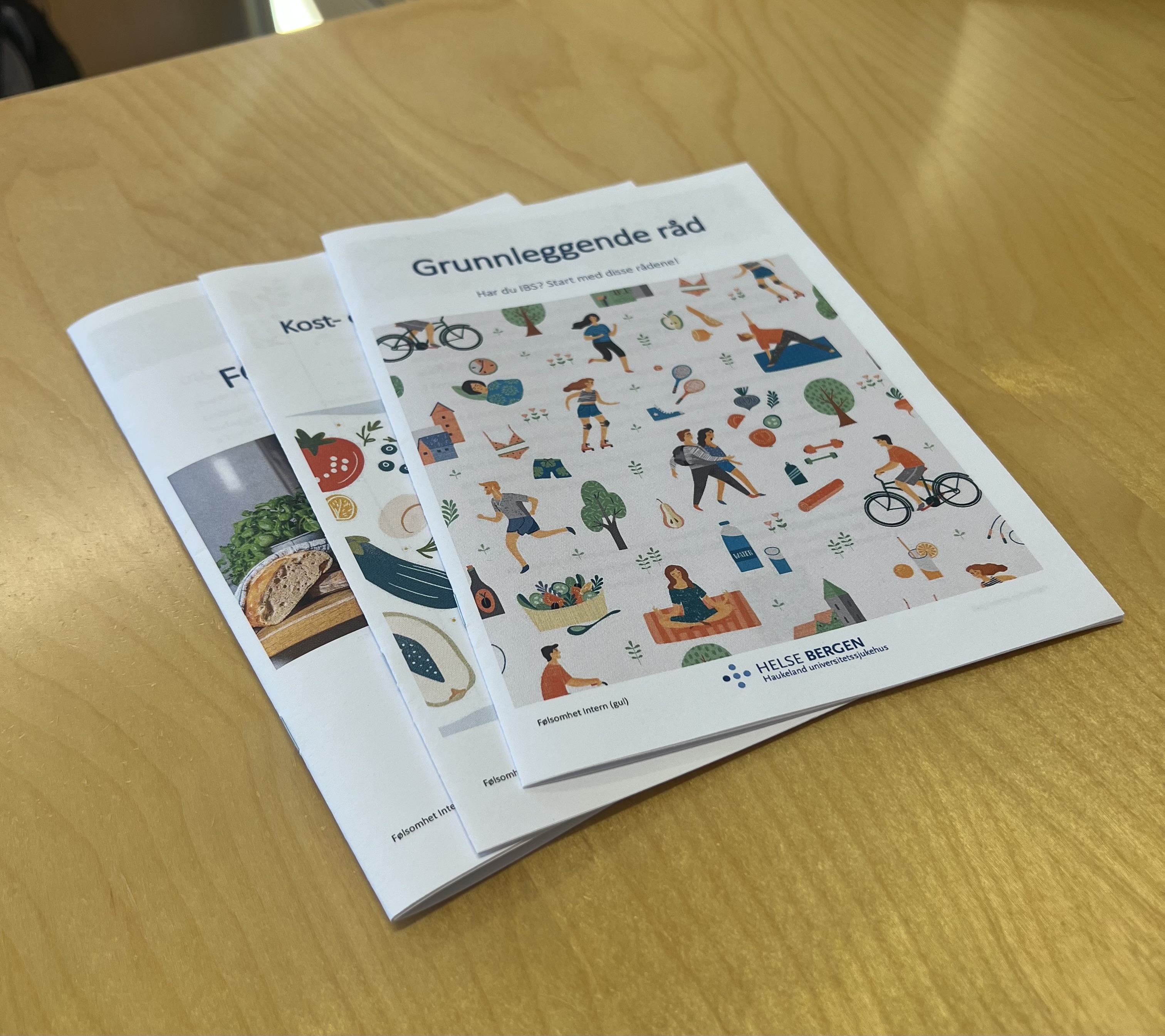 Brosjyrer med Helse Bergen-logo som ligger på et bord