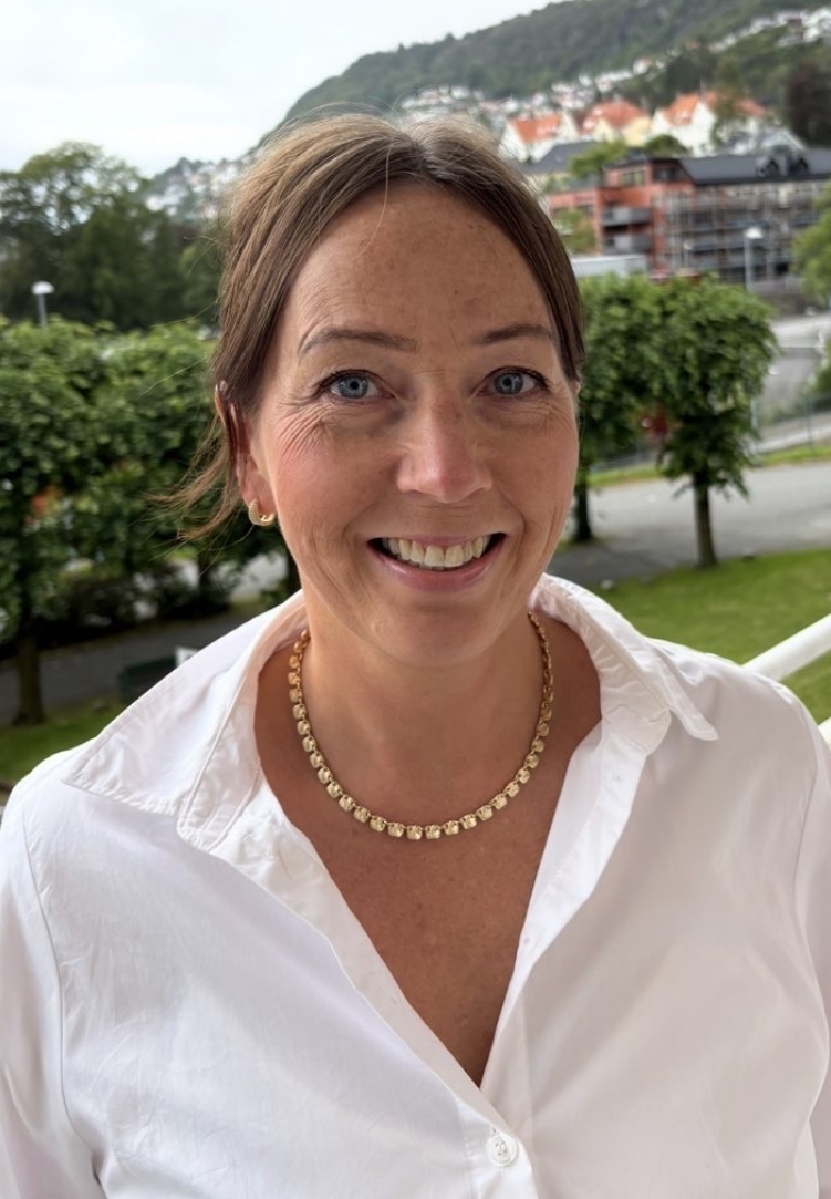 En kvinne som smiler til kameraet