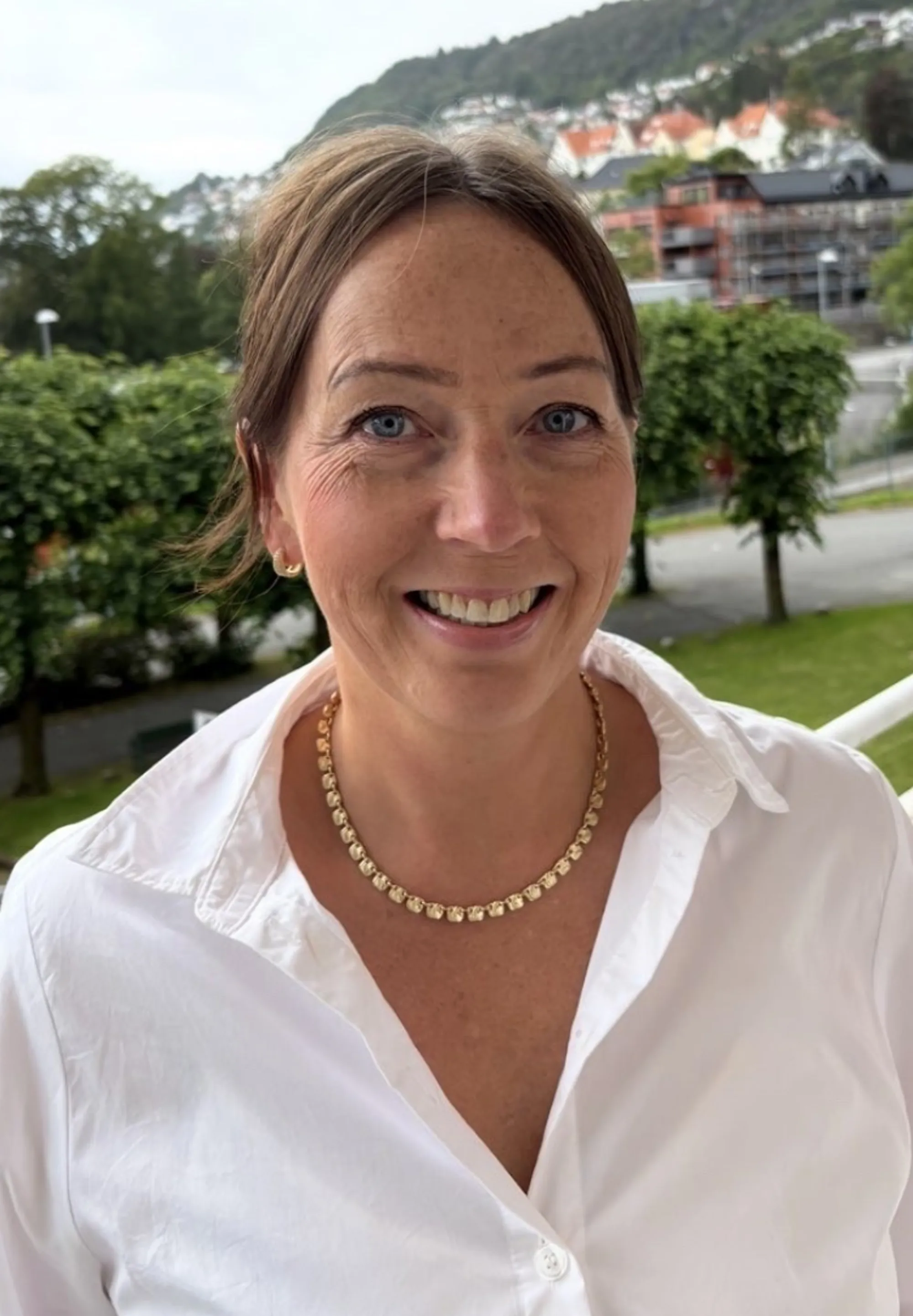 En kvinne som smiler til kameraet