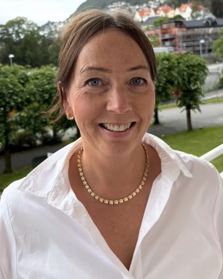 En kvinne som smiler til kameraet