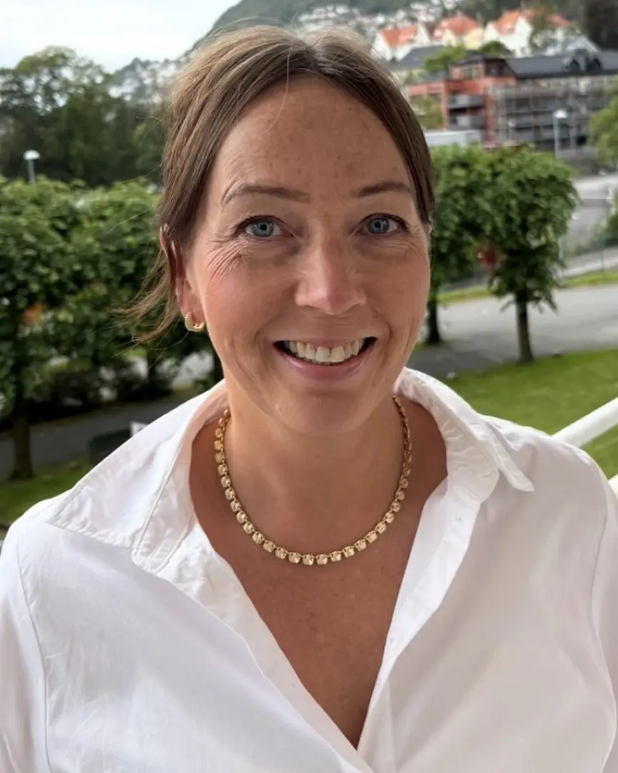 En kvinne som smiler til kameraet