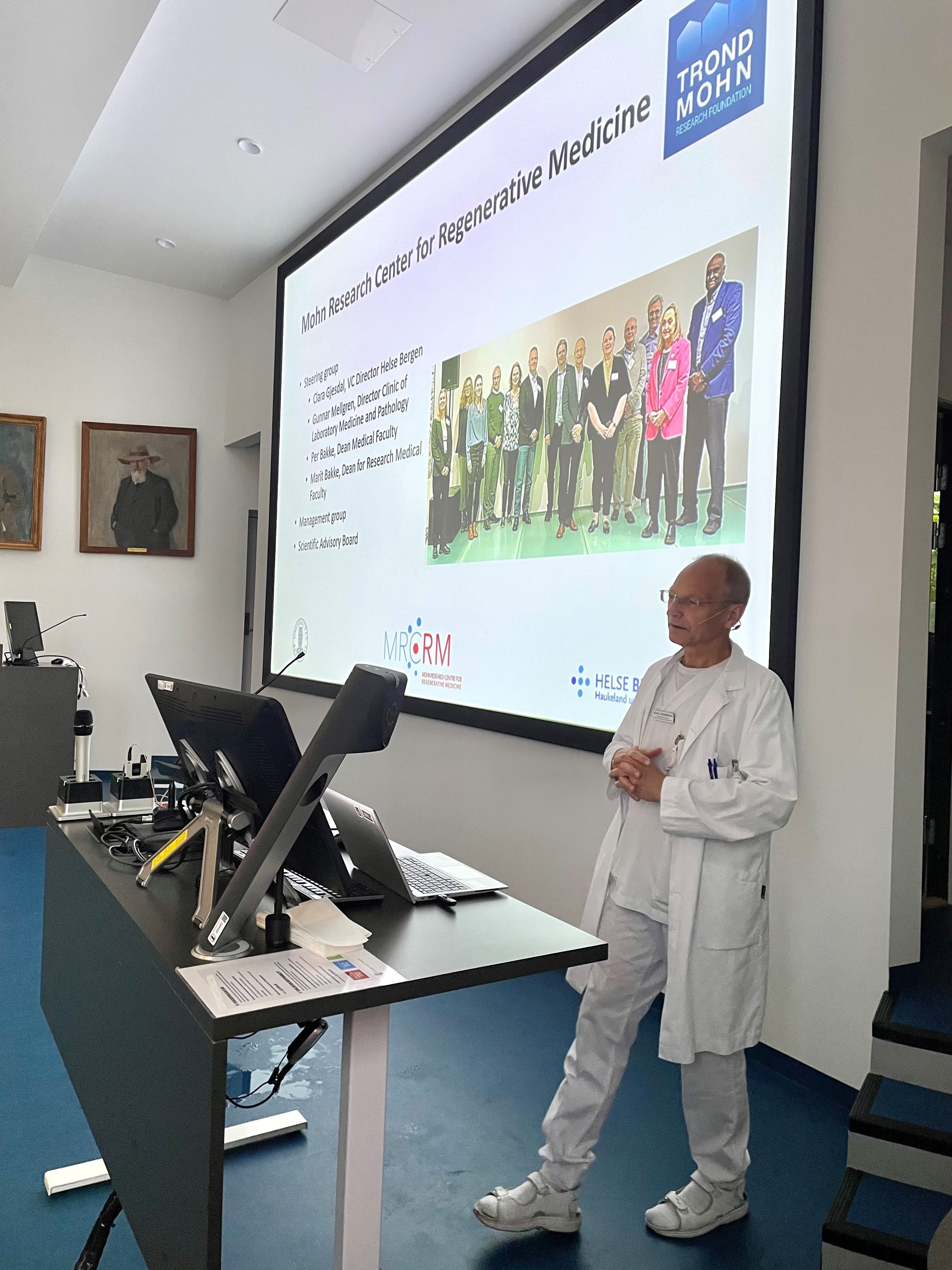 A person standing in front of a large screen