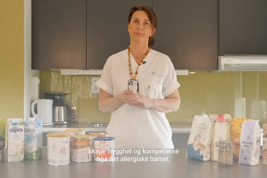 En person som står bak en disk med en gruppe produkter på