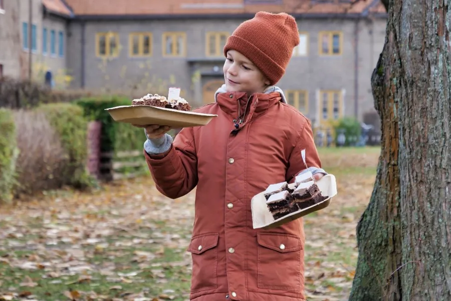 En gutt som holder en tallerken med mat