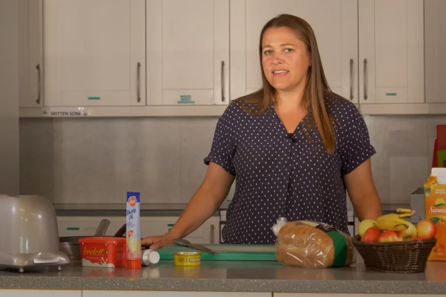 En kvinne som sitter ved en kjøkkenbenk