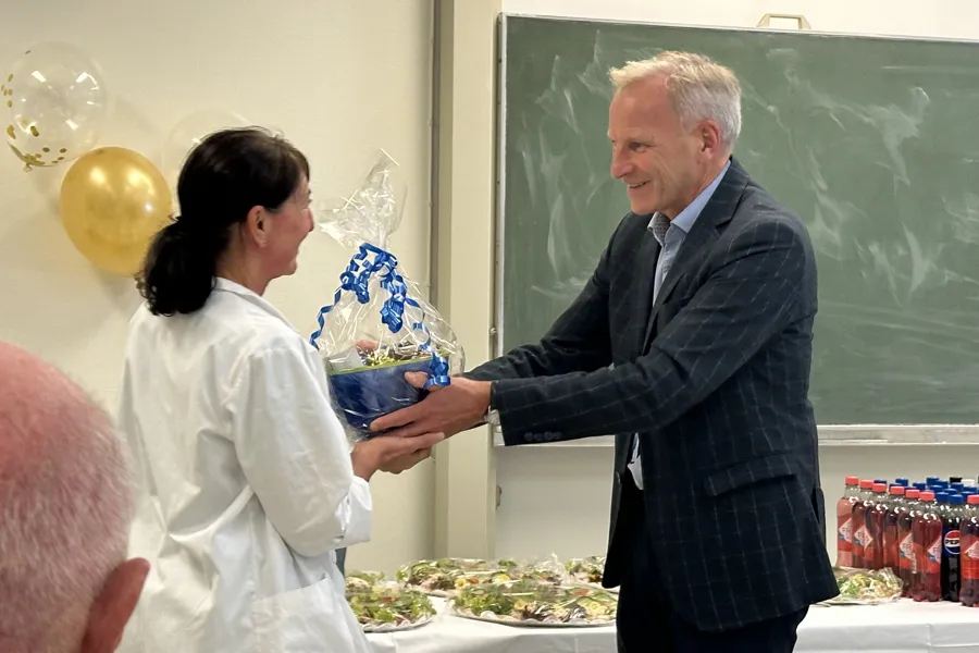 Administrerende direktør ved Haukeland universitetssjukehus, Eivind Hansen ovverrekker en skål med tvist til Avdelingssykepleier Liv Hege Furnes Hilt.