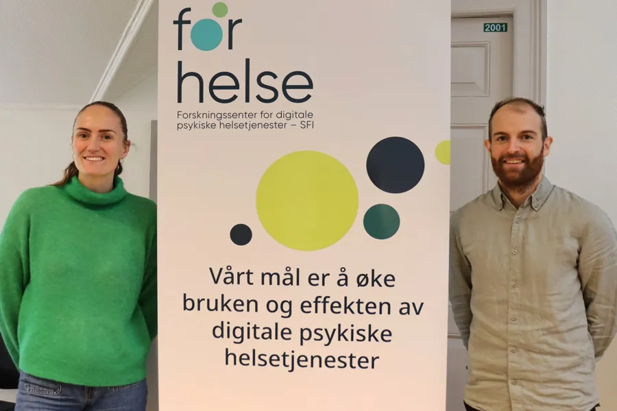 En mann og en kvinne som står ved siden av et skilt