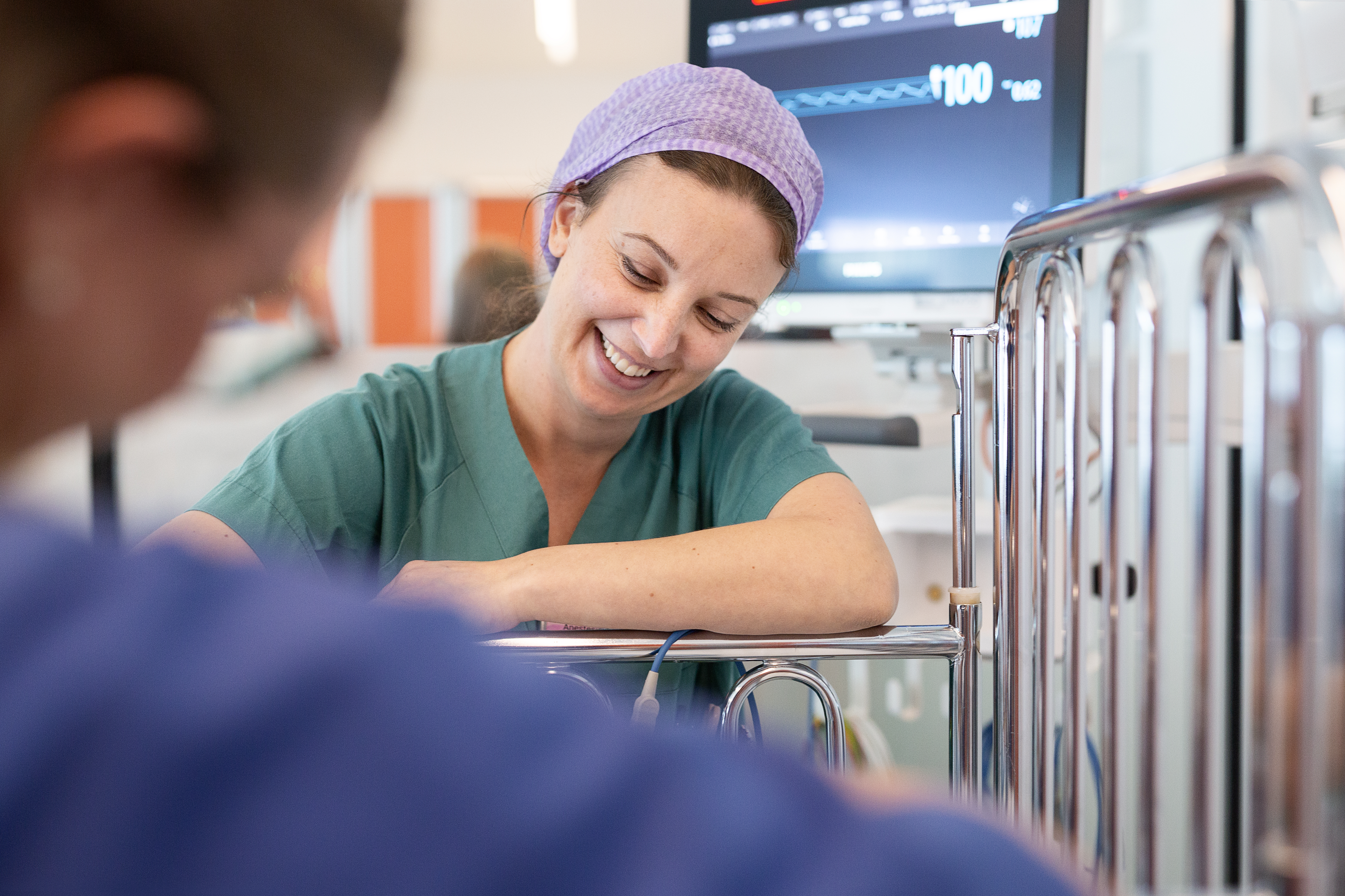 Smilende ansatt ved barneseng_foto