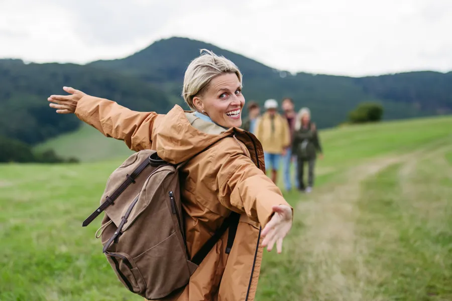 Dame står på et jorde og strekker ut armene