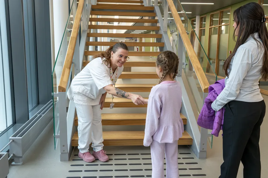 Sykepleier ønsker jente velkommen