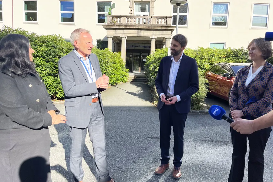 En gruppe mennesker som står utenfor