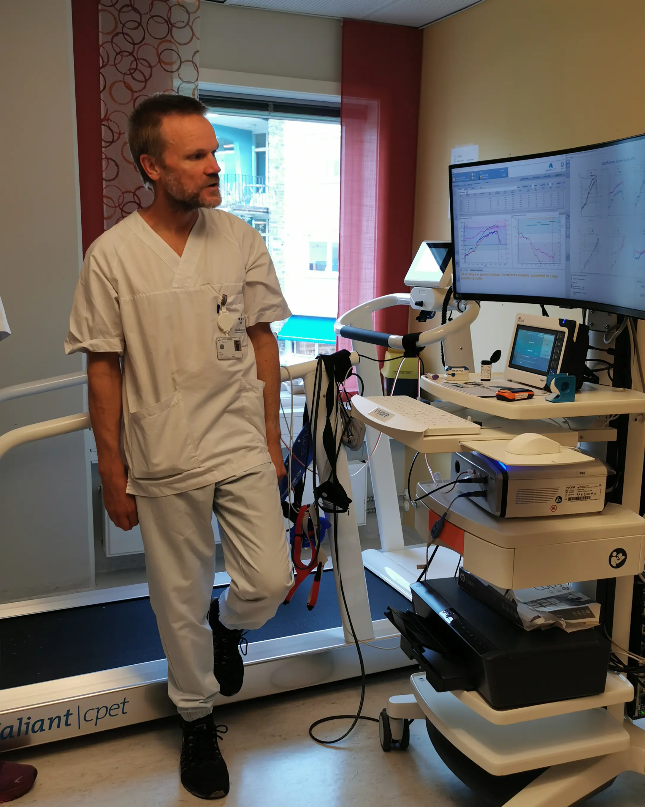 En mann i helseuniform ved en tredemølle