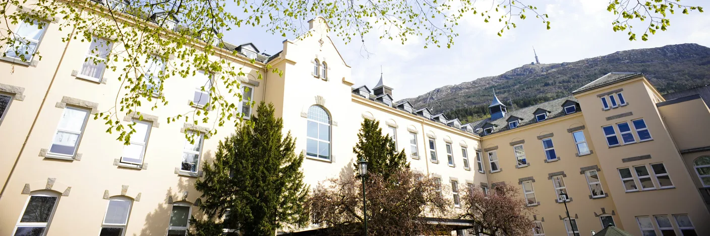 En gruppe bygninger med trær foran seg