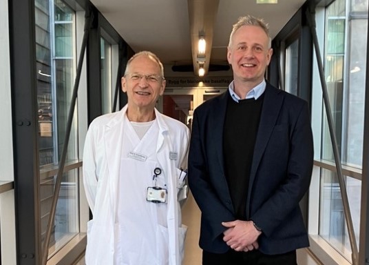 A man and a woman standing in front of a glass wall