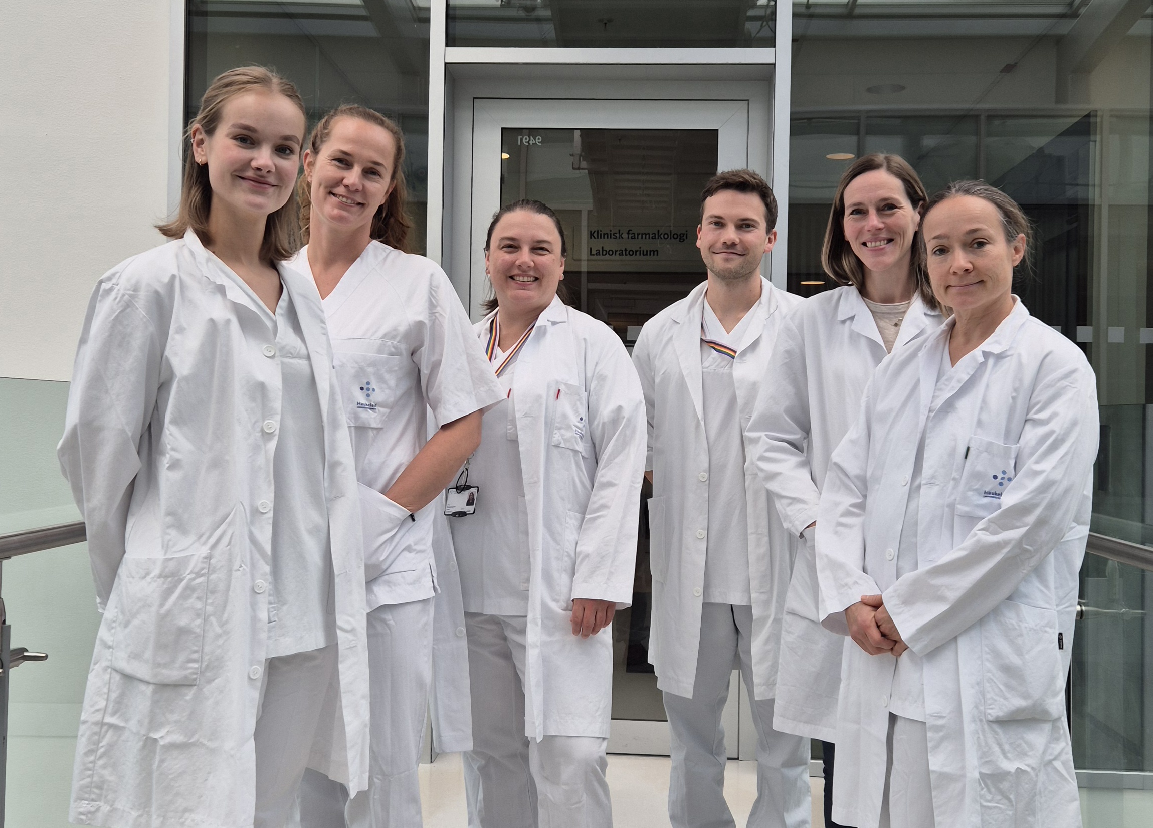 En gruppe mennesker iført hvite laboratoriefrakker