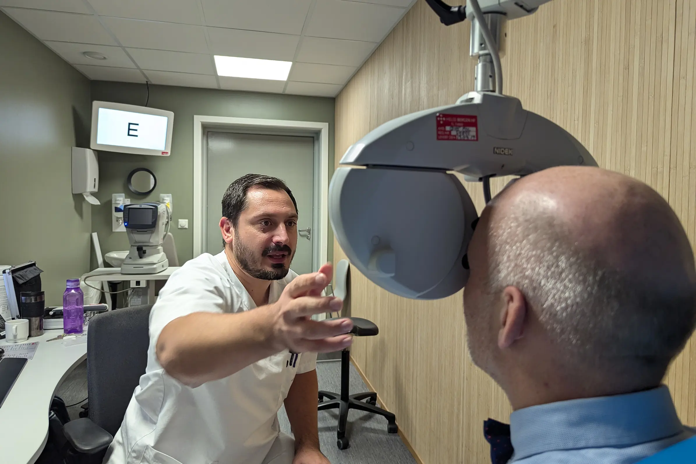 En mann som sitter i en stol ved siden av en mann i hvit skjorte