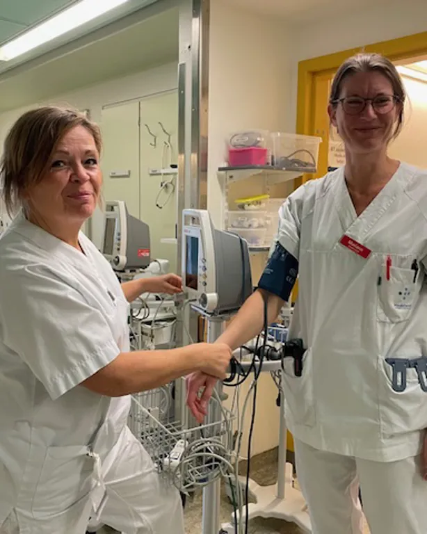 Et par kvinner i hvite laboratoriefrakker