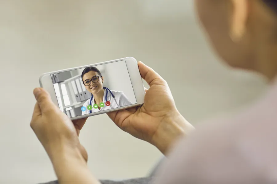 Person ser på mobiltelefon som benyttes til digital hjemmeoppfølging