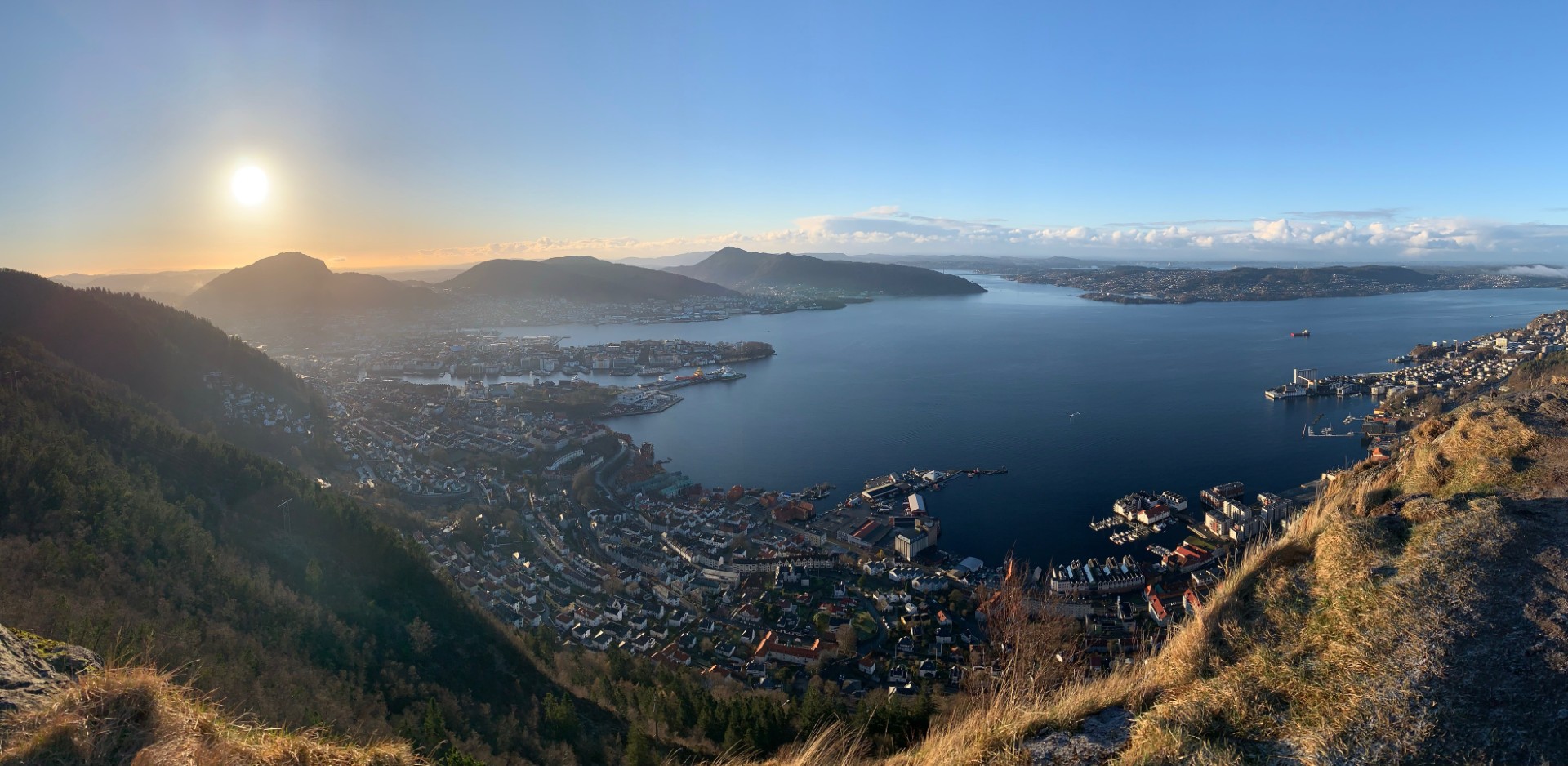 En vannmasse med land rundt seg og en by i det fjerne