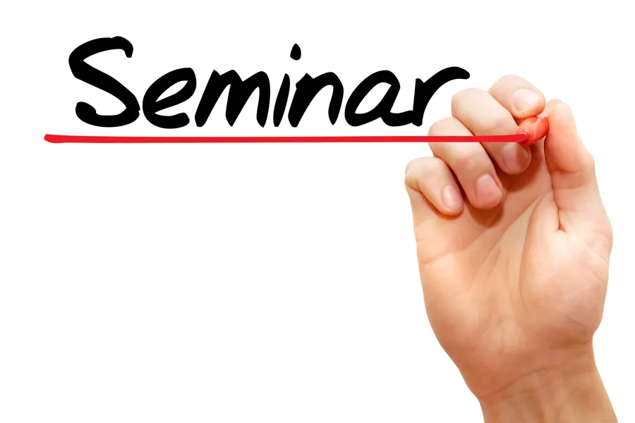 Seminar written and underscored with red pen in hand. Photo