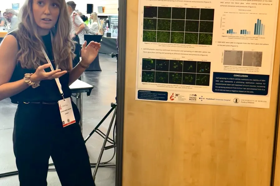 Woman standing besides poster. Photo