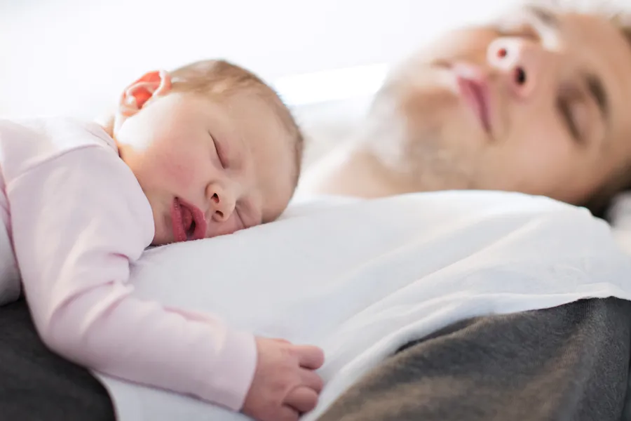 Barn sover på brystet til far