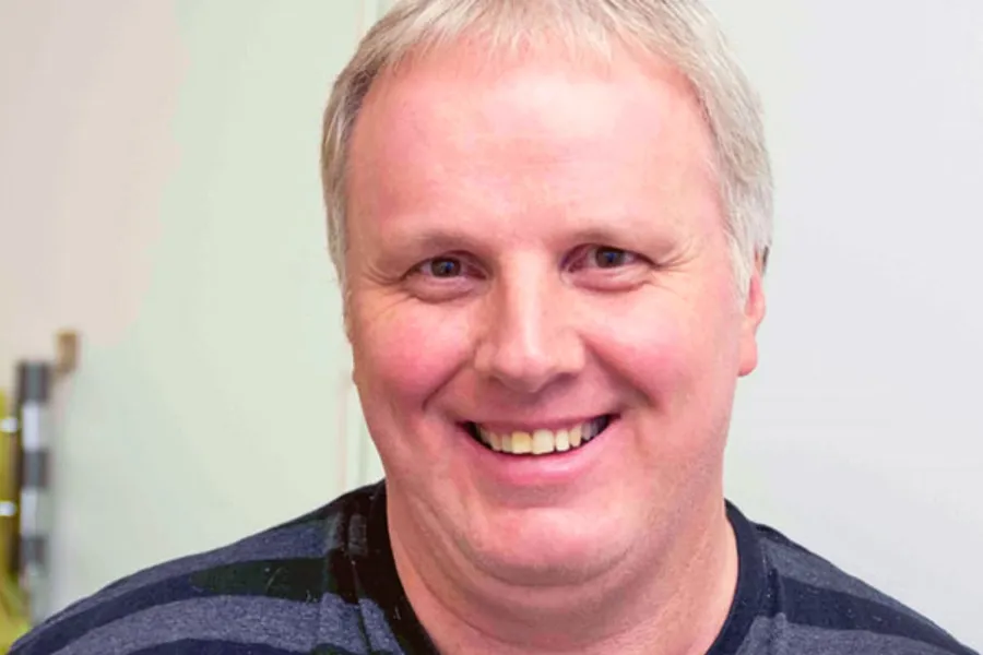 En mann som smiler til kameraet