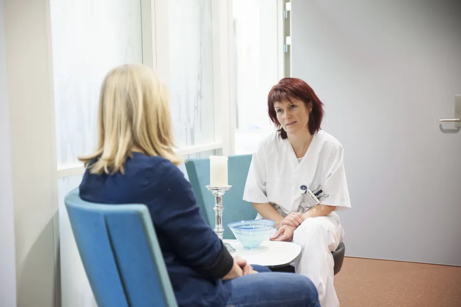 Helsepersonell i samtale med pasient. Foto