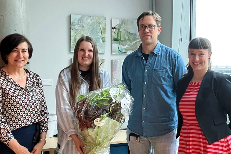Masterstudent avbildet med sine tre veiledere
