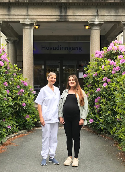 Jordmor og høggravid kvinne utanfor Kvinneklinikken.