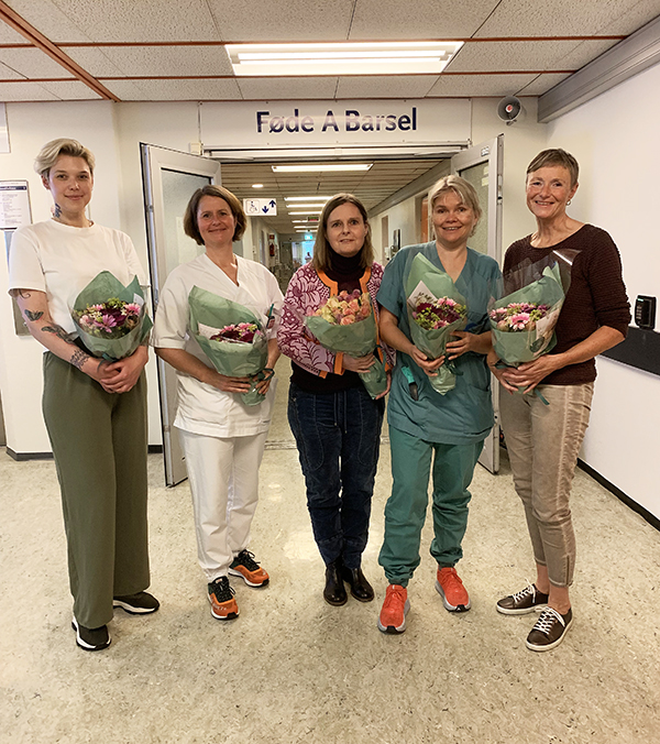 Fem damer med kvar sin blomebukett.