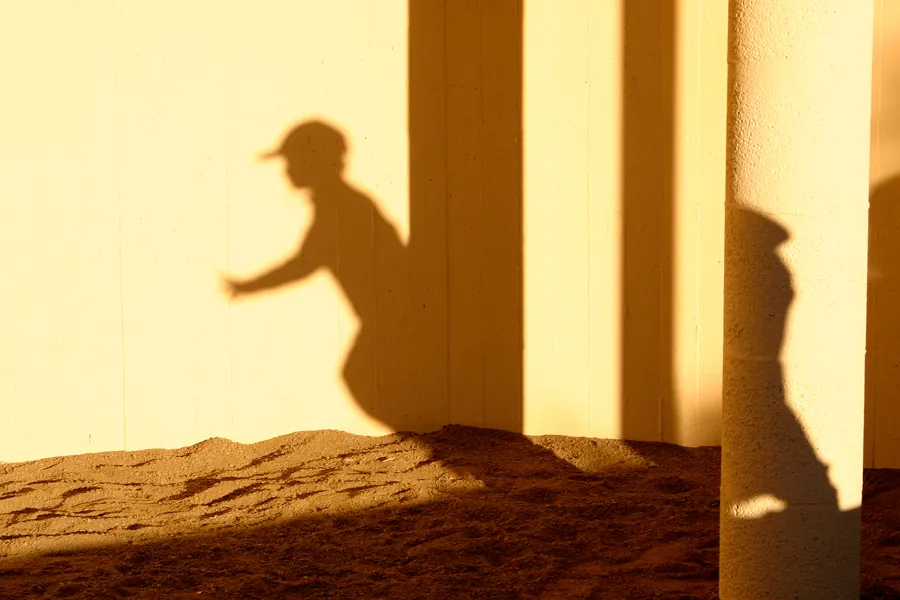 Skygge av gutt i solnedgang