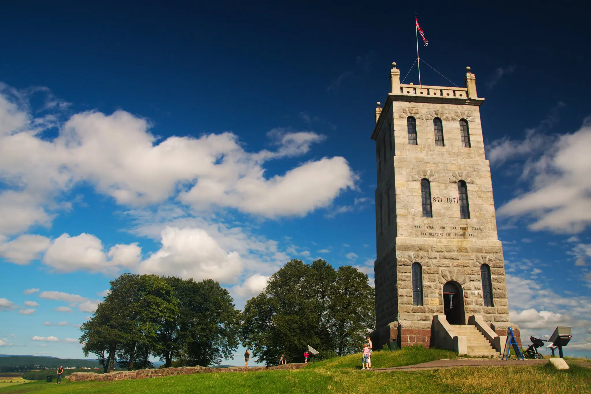 Eksteriør Slottsfjellet i Tønsberg, tårn, trær, blå himmel og hvite skyer. Foto