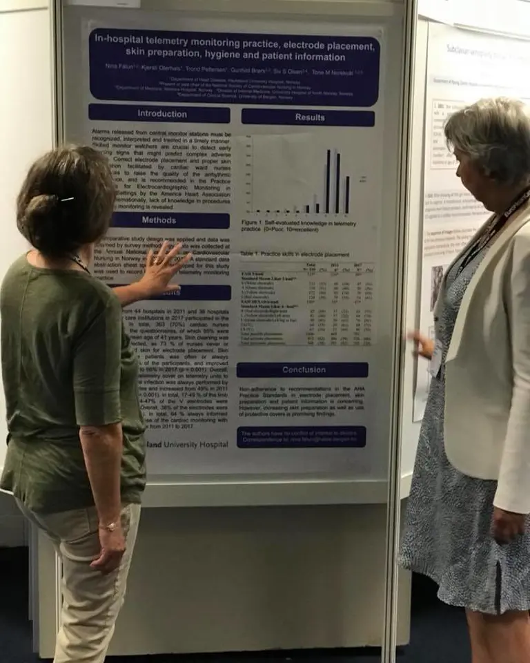 Kjersti og Nina står ved poster på konferanse. Foto