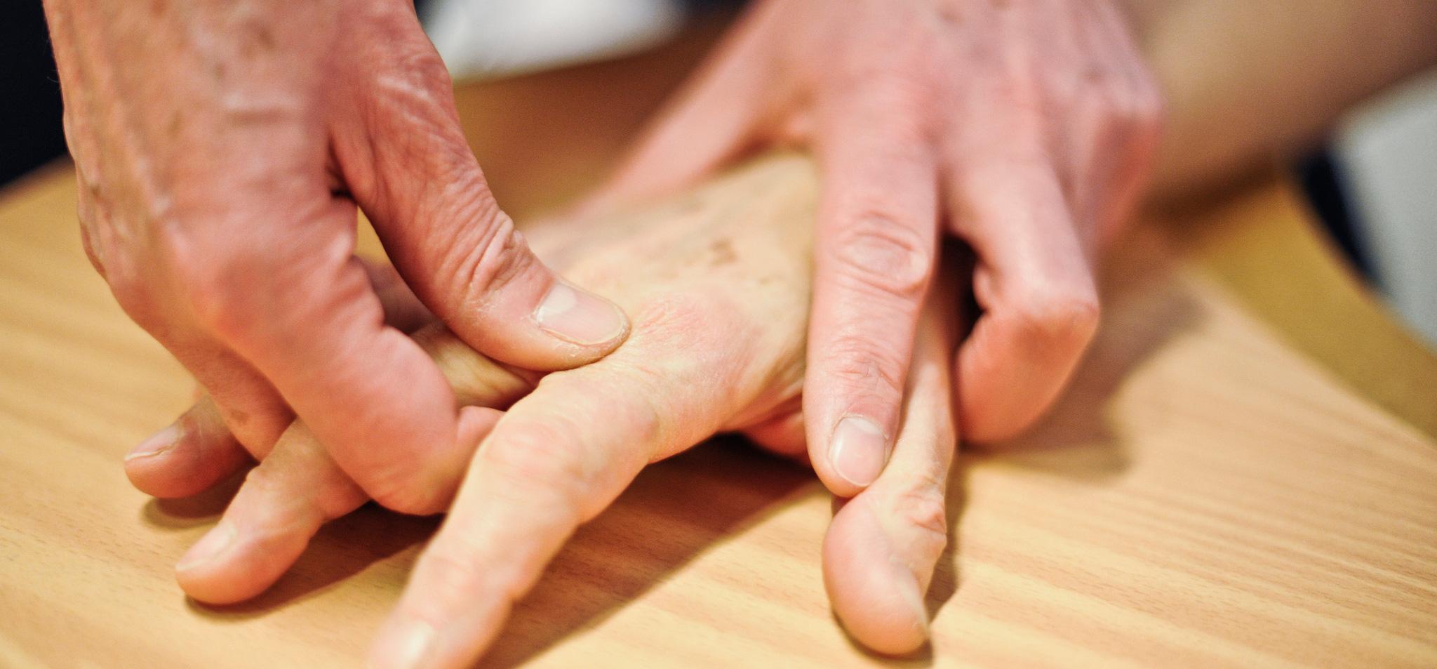 Et nærbilde av hender som holder en treplate