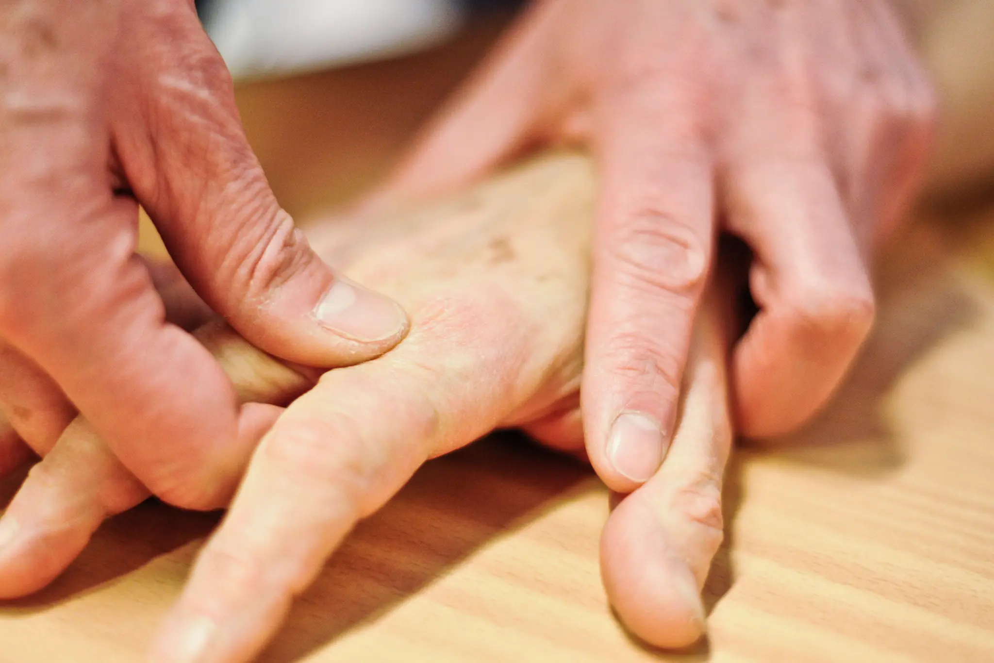 Et nærbilde av hender som holder en treplate