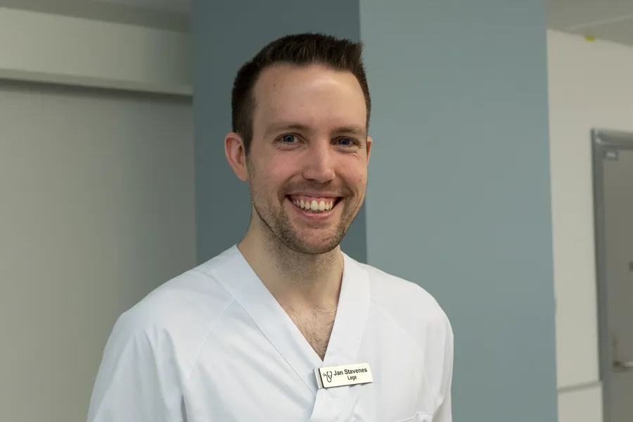 En mann som smiler til kameraet