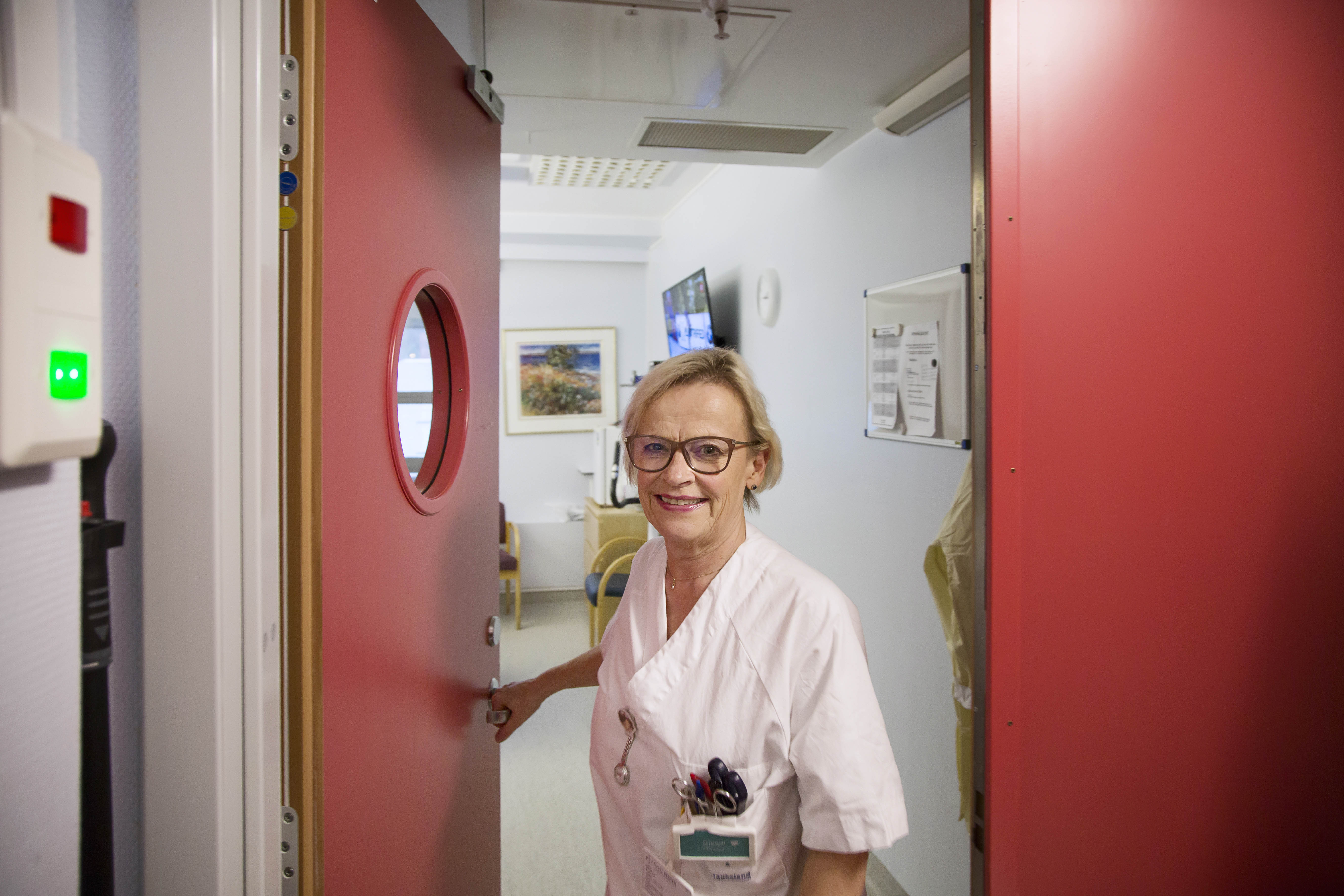 sykepleier smiler i dør.foto