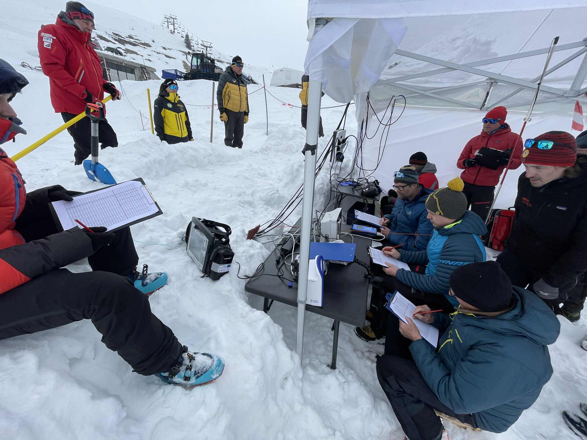 En gruppe mennesker som sitter på snøen