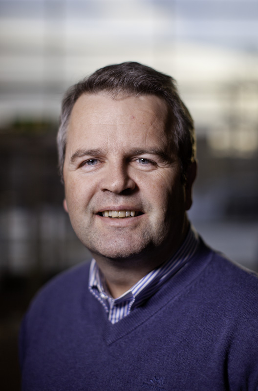 En mann som smiler til kameraet