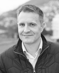 En mann som smiler til kameraet